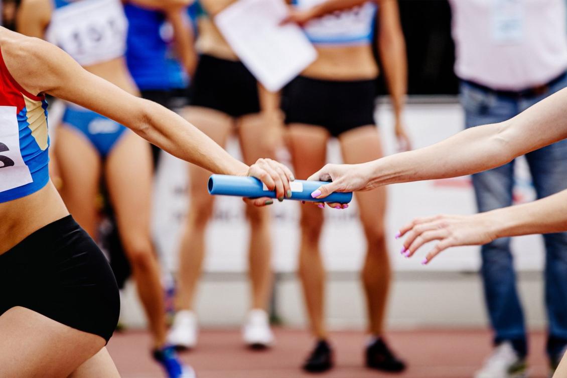 A baton pass during a track relay race.