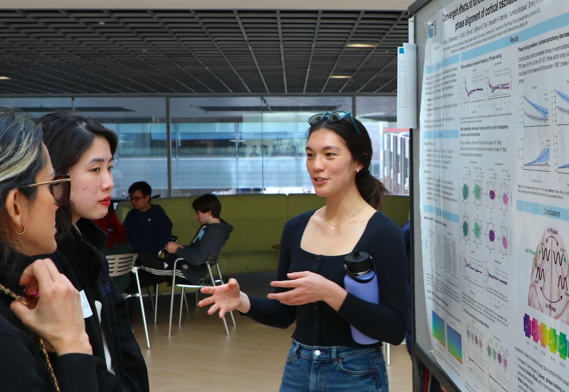 Alexandra Bardon speaking in front of a poster displaying her research